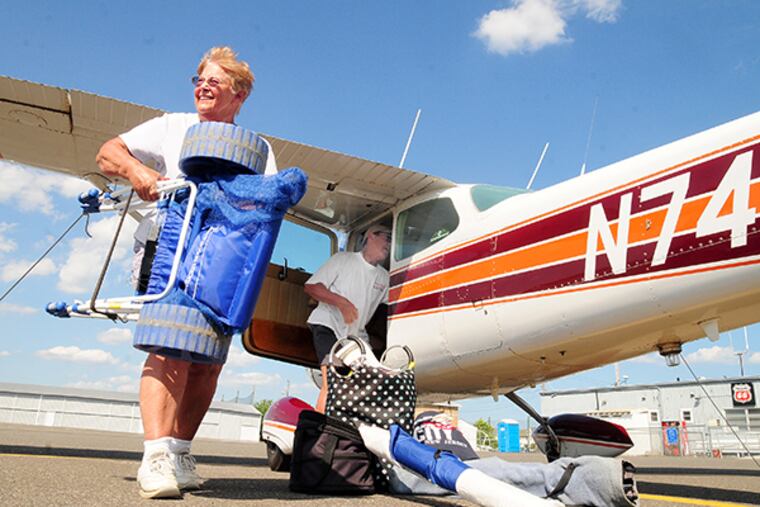 Bud and Carol Laird, from West Chester, Pa., start to load up their beach gear before heading home in their Cessna 172 Skyhawk from the Ocean City Municipal Airport in Ocean City, N.J. ( DAVE GRIFFIN / For the Inquirer )