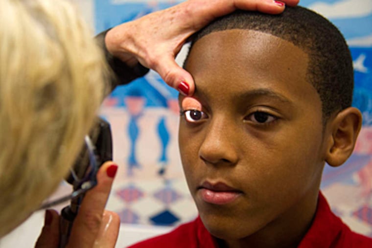 Jordan Goins,12, is examined by pediatrician Cheryl Hausman.When he had symptoms after hitting his head, his mother made him undergo "cognitive rest." (CLEM MURRAY / Staff Photographer)
