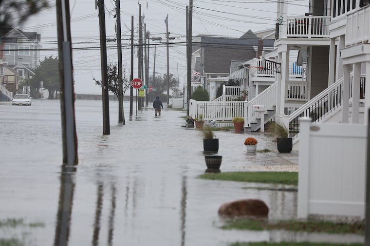 A pedestrian walks along a flooded 13th Avenue in North Wildwood on Oct. 12 in the aftermath of the potent nor'easter.