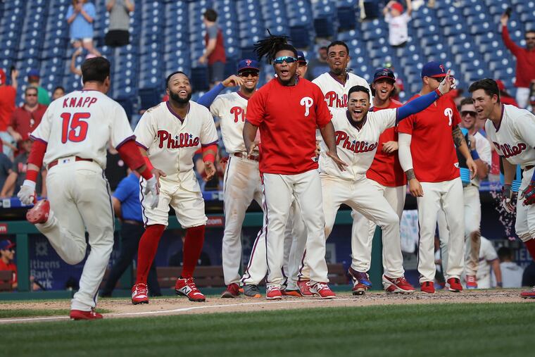 Andrew Knapp is greeted by his teammates at home plate after hitting a walkoff home run in the bottom of the 13th inning to give the Phillies the 4-3 win over the National on Sunday at a steamy Citizens Bank Park.