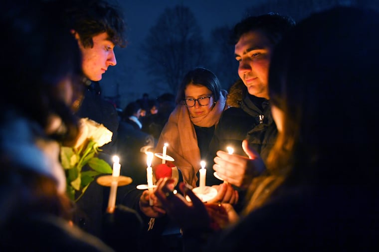People hold candles during a vigil Sunday in Providence, R.I., for those injured and killed during the Saturday shooting on Brown University campus.