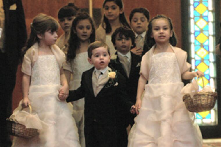 bow their heads after being crowned king and queen of the day and of their house- hold, an Armenian custom, at St. Gregory the Illuminator Armenian Apostolic Church. Children of the bride's closest friends made up the bridal party.