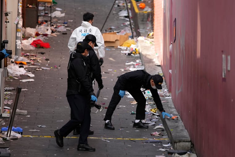 South Korean investigators on Monday inspect the scene of a crowd surge that killed more than 150 people in Seoul over the weekend.