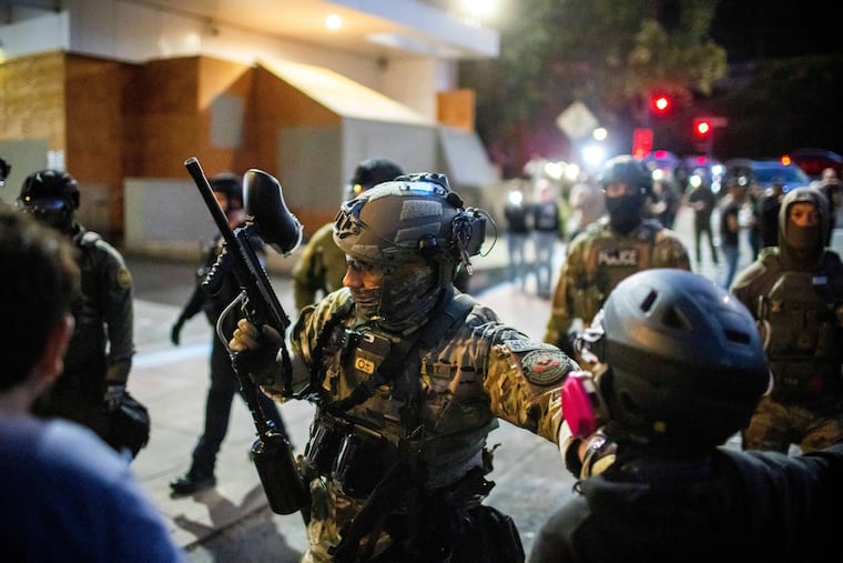 Police and Federal officers guard an area near the U.S. Immigration and Customs Enforcement facility in Portland, Ore., on Sunday, Oct. 5.