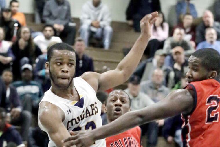 M.L. King's Jabri McCall makes a nifty pass under the arm of PW defender Cameron Johnson while driving to the hoop in the fourth quarter. ELIZABETH ROBERTSON / Staff Photographer