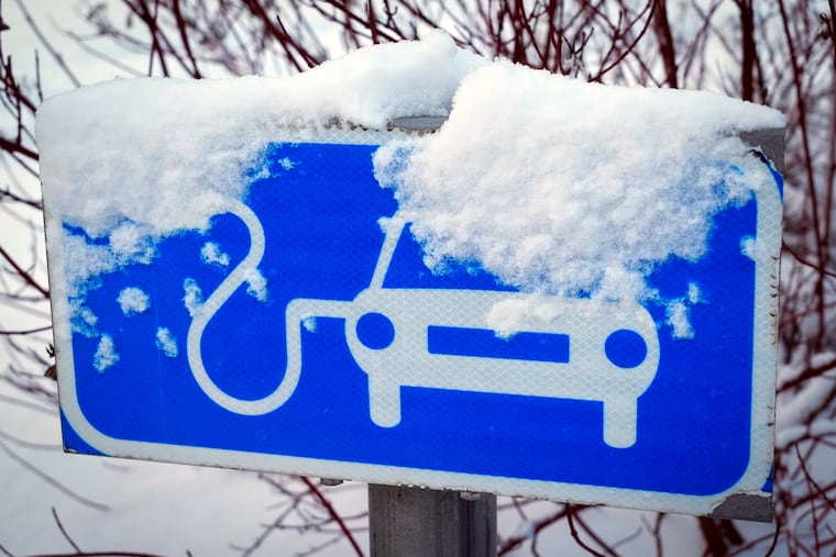A sign for charging electric cars is covered in snow in Tallinn, Estonia, Saturday, Feb. 11, 2023. Many electric vehicle batteries lose power when it's very cold.