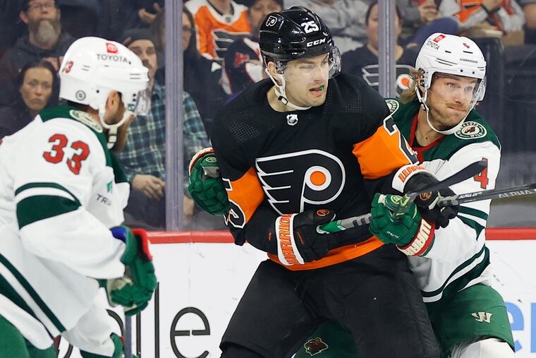 Flyers left wing James van Riemsdyk reaches for the puck against Minnesota Wild defenseman Jon Merrill.