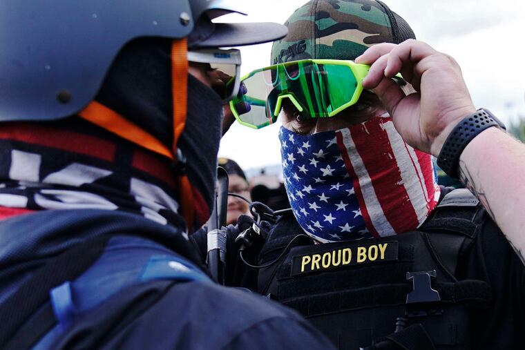 A member of the Proud Boys, right, stod in front of a counter protester as members of the Proud Boys and other right-wing demonstrators rallied on Sept. 26 in Portland, Ore.