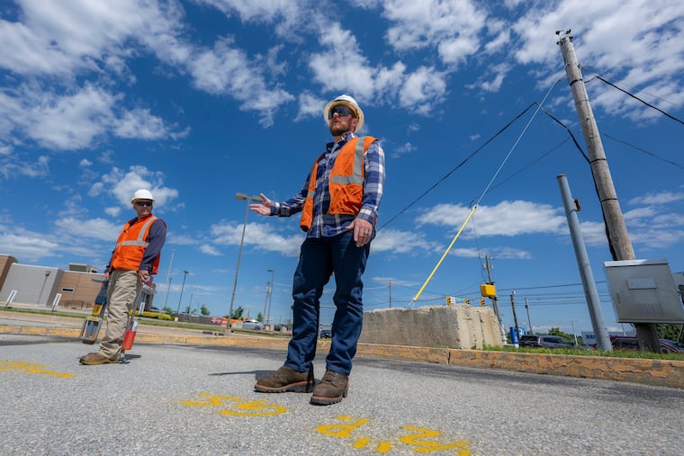 Damage prevention inspector Bryan Lloyd (left) and Peco gas supervisor Michael Onimus mark the ground to show where utilities are underneath.