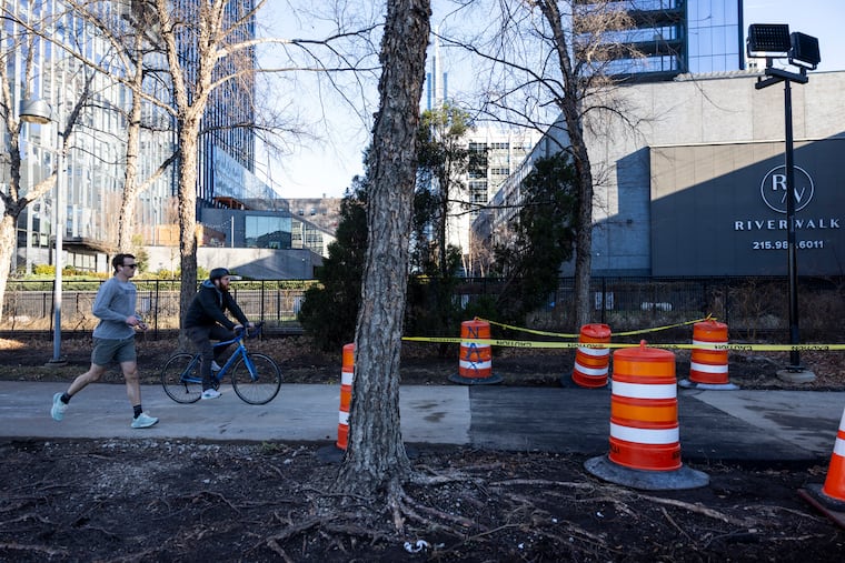 A cyclist rides on a repaired area of a sinkhole that had part of the Schuylkill River Trail closed between JFK Boulevard and Race Street. The area was reopened Dec. 24, 2025.