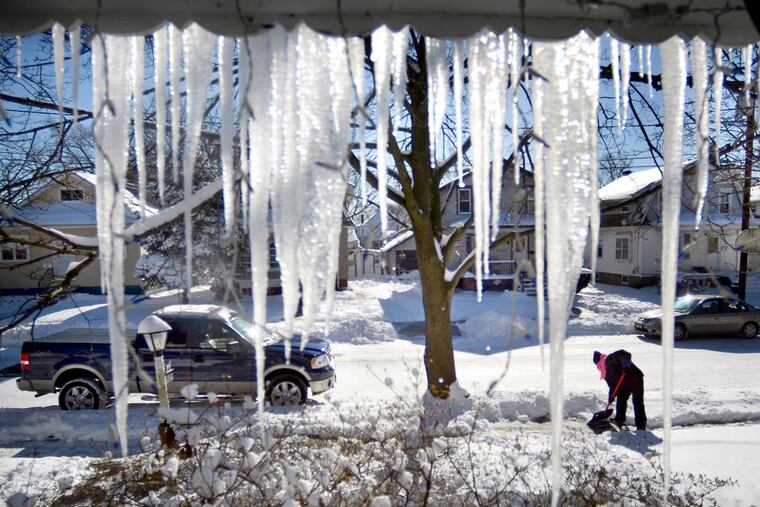 Jodi O'Brien shovels the walk outside the icicled front porch of her home on Hillcrest Avenue in Oaklyn in January, 2014. More rain than snow is likely this weekend. TOM GRALISH / Staff Photographer