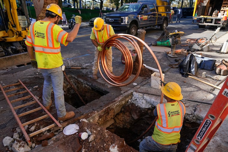 Workmen prepare to replace older water pipes with a new copper one in Newark, N.J., in 2021. An ambitious program to replace thousands of residential lead water lines in New Jersey's largest city was expected to be completed years ahead of schedule.