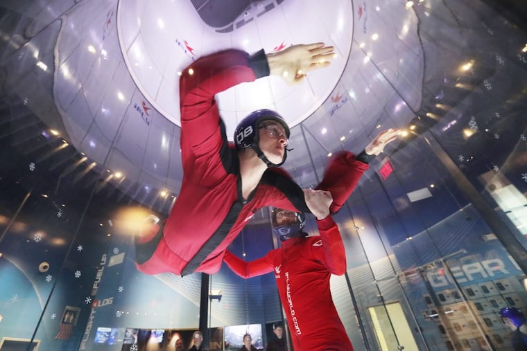 Patrick McMillan, 18, spends a cold day inside, flying with instructor Dave Catena at iSKY King of Prussia, on Saturday. The day’s 15-degree high set a new record for a Jan. 6.
