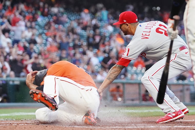Jason Vosler (32) of the San Francisco Giants slides past Vince Velasquez (21) of the Philadelphia Phillies to score during the second inning at Oracle Park on June 18, 2021 in San Francisco.