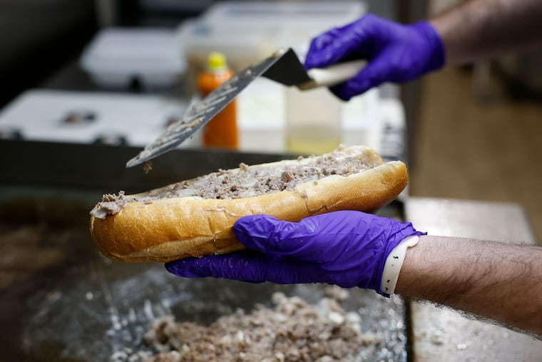 Visiting clubhouse assistant Eric Michaels prepares a cheesesteak at Citizens Bank Park before the Phillies played the Arizona Diamondbacks on May 2.