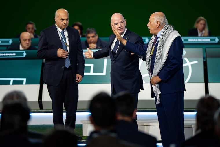 Palestinian Football Association president Jibril Rajoub (right) waving off FIFA president Gianni Infantino's attempt to get Rajoub to shake hands with Israel Football Association vice president Basim Sheikh Suliman (left).