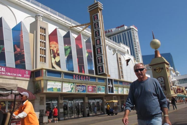 Pedestrians walk in front of Resorts Casino Hotel on Friday, Sept. 14, 2012, in Atlantic City, N.J. New Jersey casino regulators announced Friday they would allow the Mohegan Indian tribe of Connecticut to run the day-to-day affairs of Resorts. The Mohegan Indian tribe plans to oversee a $35 million expansion of Resorts that will include a Jimmy Buffett-themed Margaritaville complex. (AP Photo/Wayne Parry)