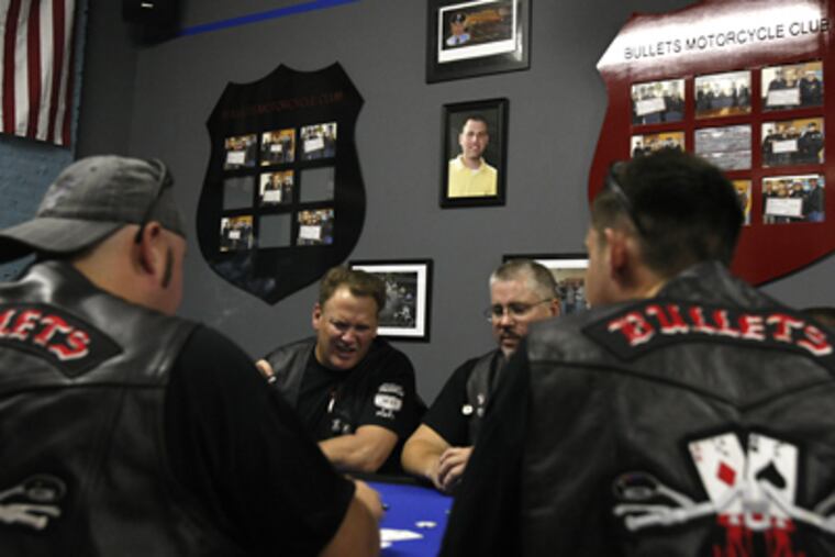 A memorial photo of Officer John Pawlowski watches over the weekly card game at a clubhouse in Port Richmond. (Ron Cortes / Staff Photographer)