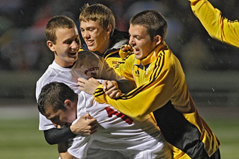 Haddon Heights' James Hicks is embraced by teammates after scoring the winning penalty shot. (David M Warren / Staff Photographer)