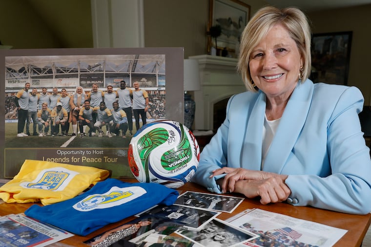 Diane McGraw, the former executive director of the Philadelphia Sports Congress poses with memorabilia from Philly's 1994 World Cup bid, which she led.