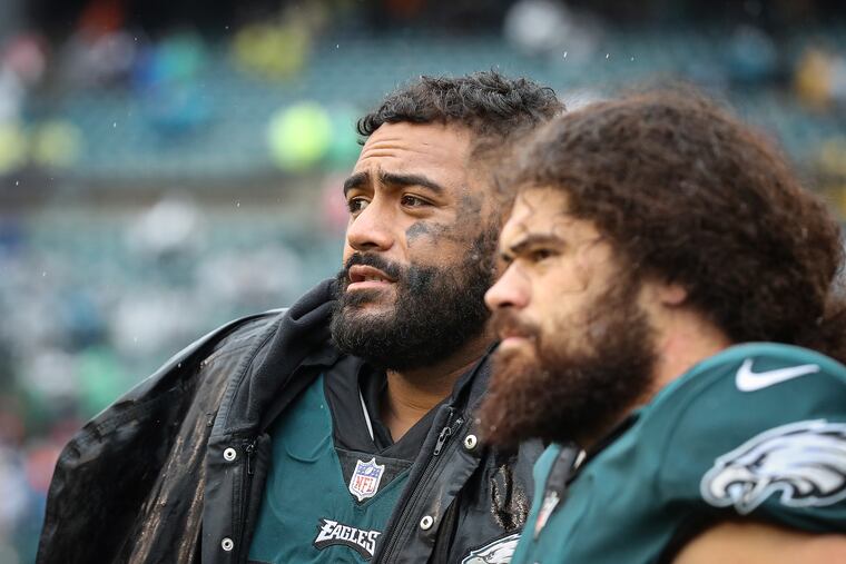 Injured Eagles offensive linemen Jordan Mailata (left) and Isaac Seumalo watch from the sideline in the fourth quarter against the Jaguars.