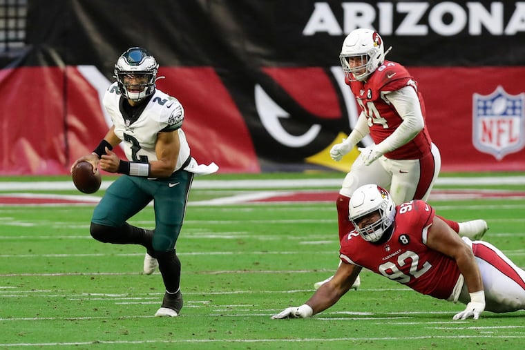 Eagles quarterback Jalen Hurts scrambles past Arizona Cardinals defensive tackle Rashard Lawrence (on ground) and defensive end Zach Allen in the second quarter.