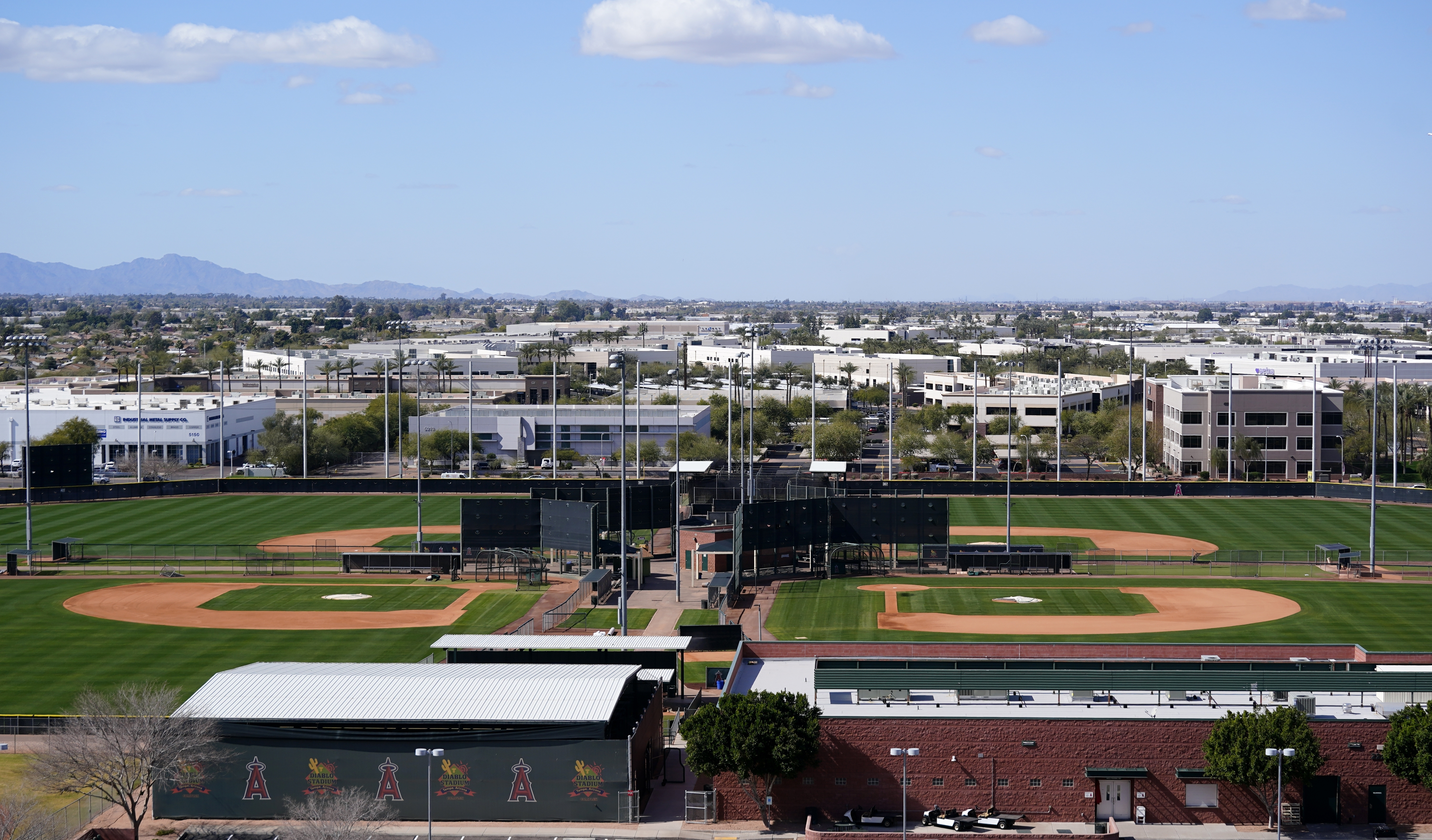 Practice fields remain empty as pitchers and catchers are not starting spring training workouts as scheduled as the Major League Baseball lockout enters its 77th day and will prevent pitchers and catchers from taking the field for the first time since October as the Los Angeles Angels facility is quiet Wednesday, Feb. 16, 2022, in Tempe, Ariz. (AP Photo/Ross D. Franklin)
