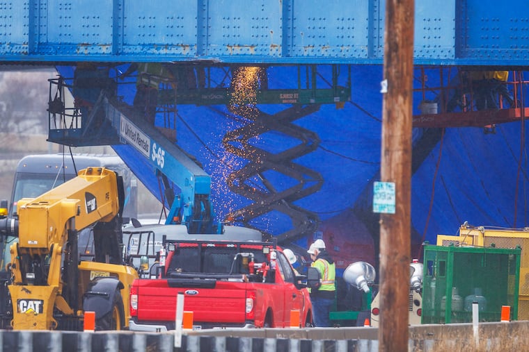 Work crews attend to damage to railroad bridge over I-95 as seen from Luzerne near Richmond Street on Tuesday.
