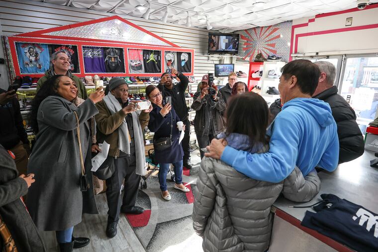Yong Lee, owner of Young's Sneaker City on West Girard Avenue in Brewerytown, poses for photos with then-Mayor Jim Kenney during a November 2023 visit to his store.