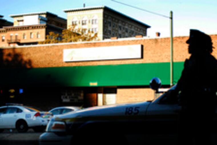 Police secure the scene of a shootout at the KoKo Bongo nightclub in University City. A suspect was killed, and a police officer and bystander were wounded yesterday morning.