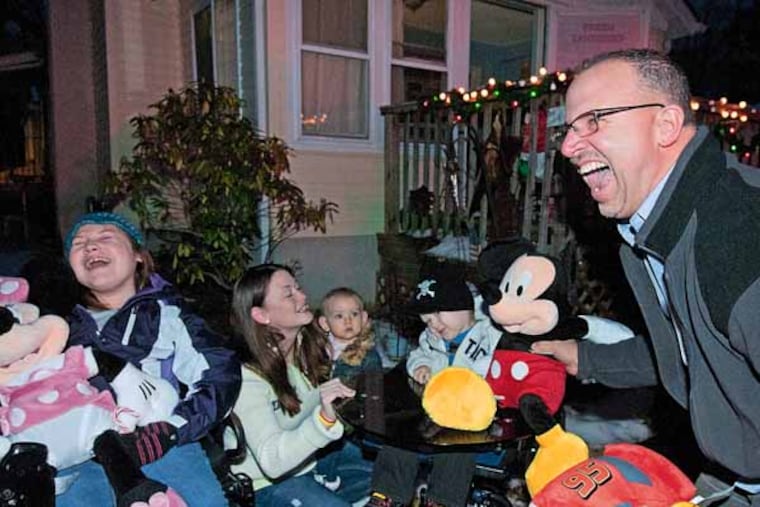 Baking Memories 4 Kids comes to the home of the Dick family in Franklin Township, NJ to tell the kids that they're getting a trip to Disneyworld on Dec. 13, 2013. Here, the organization's founder, Frank Squeo, right, gives the family--from left to right, Alexus Dick, 12; Rebecca Dick holding Ava Dick, 1; and Zane Dick, 2; the news. ( APRIL SAUL / Staff )