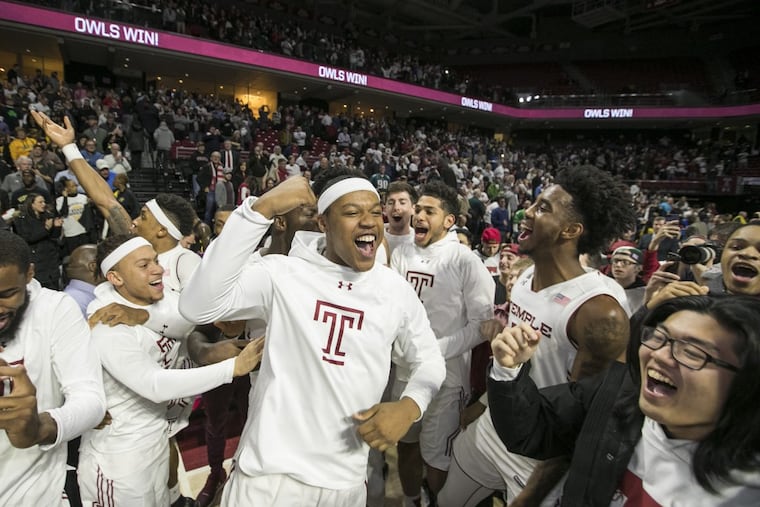Temple players, including J.P Moorman, center, celebrate as students storm the court following TempleÕs 81-79 overtime victory over Wichita State at the Liacouras Center on Feb. 1, 2018.