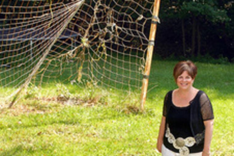 "I'll be a soccer mom now," Jayne King said, pausing by the net at her Medford home. Two of her three sons play in college.