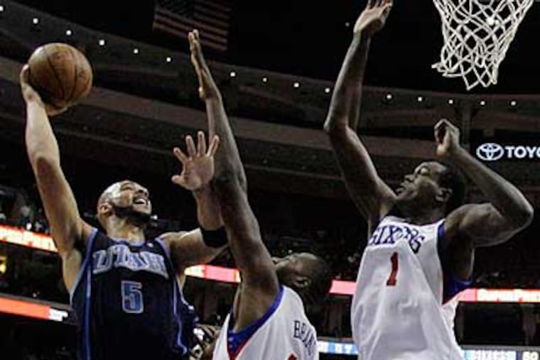 Utah Jazz's Carlos Boozer, from left, goes up for a shot as Philadelphia 76ers' Elton Brand, center,and Samuel Dalembert, right, defends in the first half. (AP Photo/Matt Slocum)