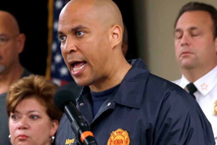 Newark Mayor Cory Booker. He and a Twitter follower, who discussed government meal funding, plan to try to live on food stamps for at least a week. "This will not be a gimmick or a stunt," he said. (Julio Cortez / AP)