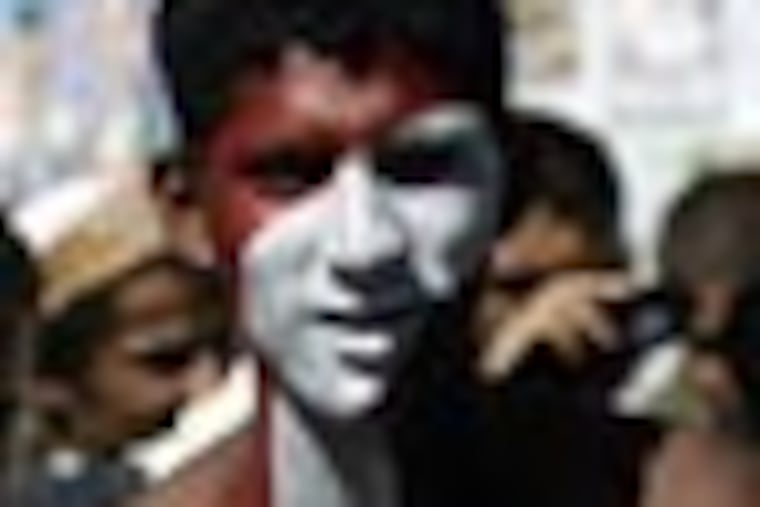 A Yemeni protestor with the colors of his national flag painted on his body and Arabic that reads: "The people want the butcher to be executed", performs a traditional dance during a rally to demand the prosecution of Yemen's president Ali Abdullah Saleh in Sanaa, Yemen Wednesday, Dec. 7, 2011. (AP Photo/Hani Mohammed)