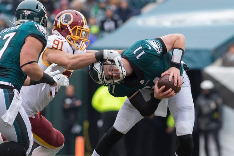 Carson Wentz, a rookie in this 2016 Eagles-Washington game, somehow escaped this attempted sack by Ryan Kerrigan.