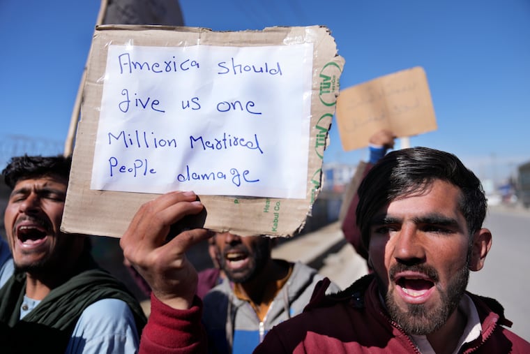 Afghan protesters hold placards and shout slogans against U.S. during a protest condemning President Joe Biden's decision, in Kabul, Afghanistan, Saturday, Feb. 12, 2022. President Biden signed an executive order, Friday, Feb. 11, 2022, to create a pathway to split $7 billion in Afghan assets frozen in the U.S. to fund humanitarian relief in Afghanistan and to create a trust fund to compensate Sept. 11 victims.