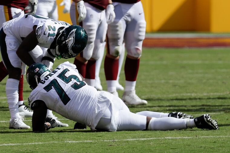 Eagles safety Jalen Mills (21) attends to injured teammate Vinny Curry (75) during the fourth quarter.
