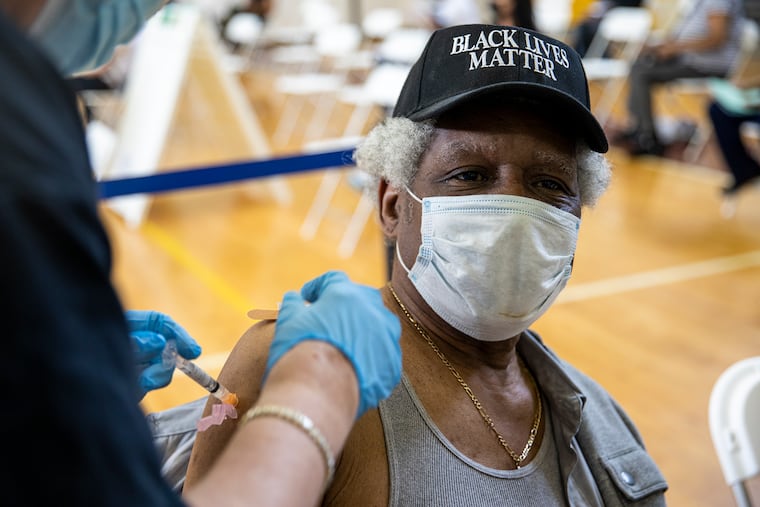 William Jones, 65, of South Philadelphia, receives his COVID-19 vaccination at the Preparatory Charter School in South Philadelphia on Saturday April 10, 2021. Jones is with his son Jermaine Jones, 35, who also got his shot today.