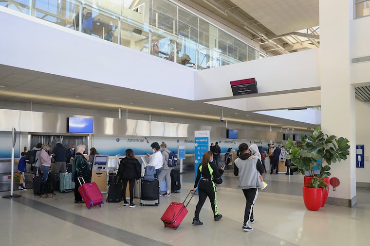 Ppassengers wait to check luggage for their flights at Philadelphia International Airport .