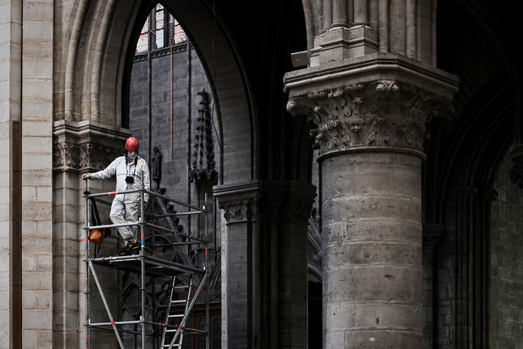 FILE - In this May 15, 2019 file photo, a worker stands on scaffolding during preliminary work inside the Notre Dame de Paris Cathedral, in Paris. The billionaire French donors that publicly promised flashy donations totalling hundreds of millions to restore Notre Dame, have not yet paid a penny toward the restoration of the French national monument, according to church and business officials. Instead, it's mainly American citizens that have footed the bills and paid salaries for the up to 150 workers employed by the cathedral since the April 15 fire.