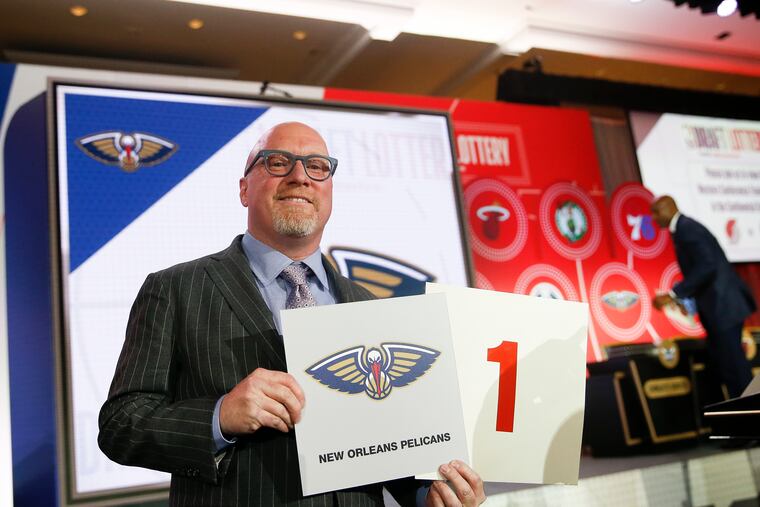 David Griffin, the New Orleans Pelicans' executive vice president of basketball operations, holds up placards after it was announced that the Pelicans had won the first pick during last year's draft lottery.