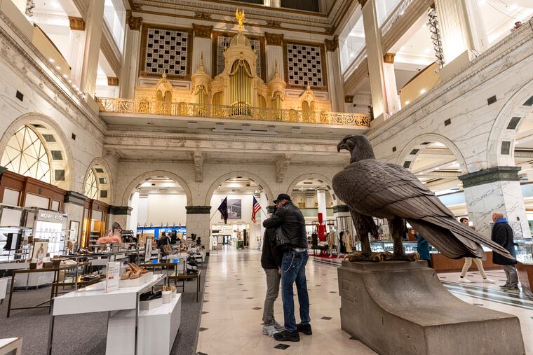 Bob Koherr, 64, and Walter Batt, 62, of Center City, share a moment together on Friday while the organ plays after the announcement of Macy's decision to close its Center City store.
