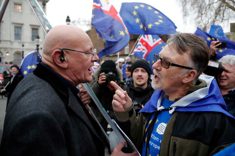A Leaver, left, and a pro-European demonstrator argue during protests opposite the Houses of Parliament in London, Tuesday, Jan. 15, 2019. Britain's Prime Minister Theresa May is struggling to win support for her Brexit deal in Parliament. Lawmakers are due to vote on the agreement Tuesday, and all signs suggest they will reject it, adding uncertainty to Brexit less than three months before Britain is due to leave the EU on March 29. (AP Photo/Frank Augstein)