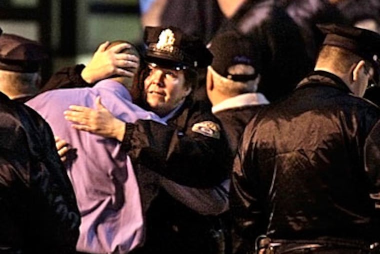 Members of the Philadelphia Police Department console each other at Temple Hospital after Sgt. Timothy Simpson was killed in a two-car crash on Nov. 17. ( Elizabeth Robertson / Inquirer / File )