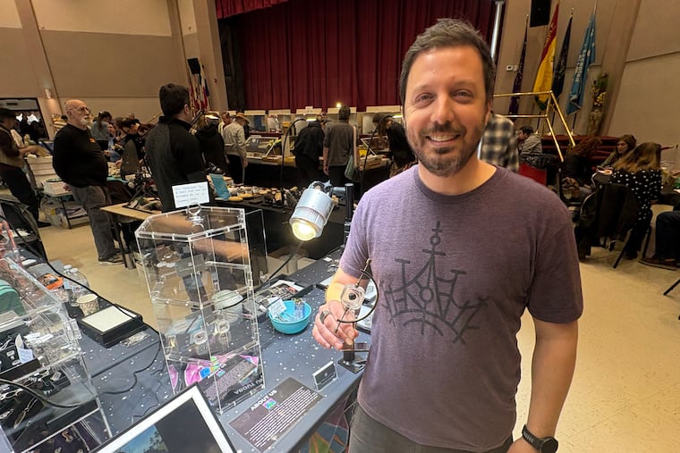 Brett Joseph Cohen, of Ambler, poses with meteorites he recovered in Ohio earlier this month.