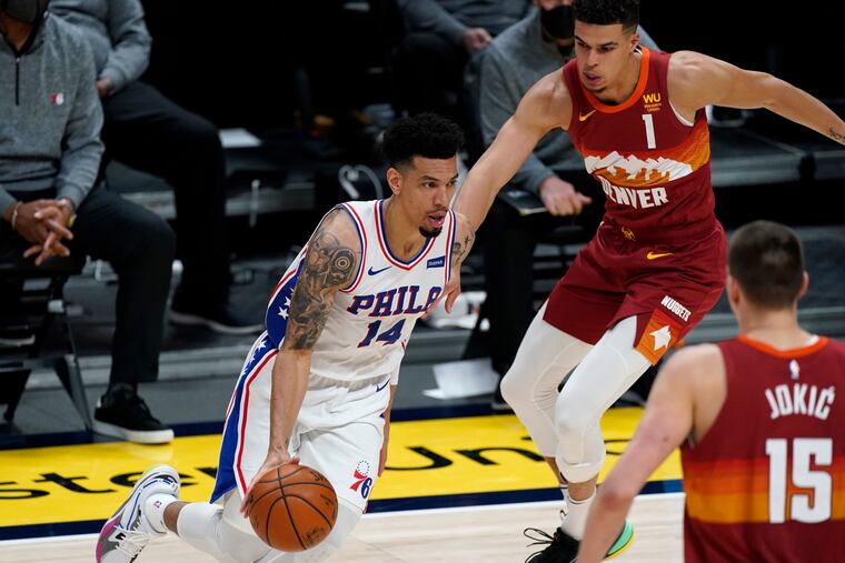Danny Green drives to the basket against two Nuggets defenders.