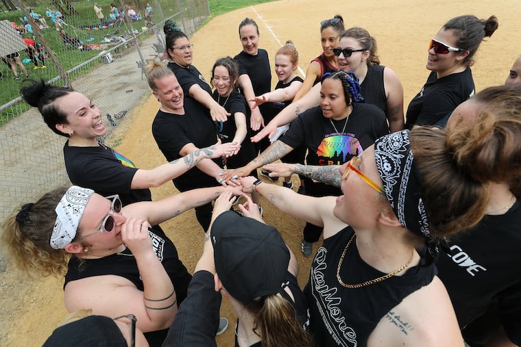 Members of the Sapphic Serpents gather after their game on opening day of the City of Brotherly Love Softball League at Dairy Fields on Sunday. The league, which started 40 years ago, is an LGBTQIA+ slow pitch softball league in Philadelphia.