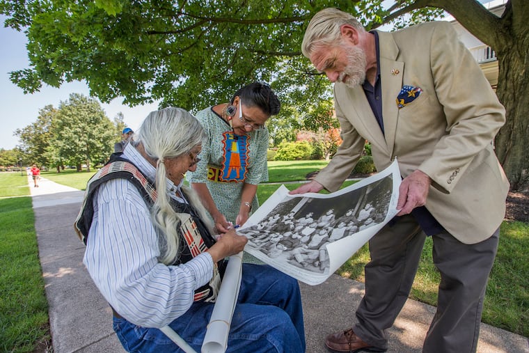 Mark Soldier Wolf, left, and his daughter, Yufna Soldier Wolf, center, look over a historical photo on on Aug. 9, 2017 as they tour the Carlisle Barracks, which once served as the Carlisle Indian Industrial School in Pennsylvania. Many non-Indigenous Americans have the misperception that Native Americans are only part of the United States' past, not its present.